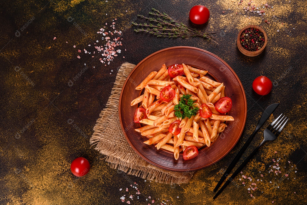 Deliciosa pasta fresca com molho de tomate com especiarias e ervas sobre fundo escuro. Cozinha mediterrânea