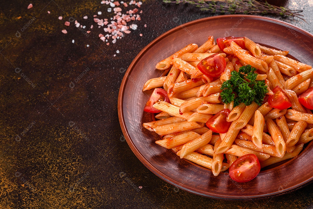 Deliciosa pasta fresca com molho de tomate com especiarias e ervas sobre fundo escuro. Cozinha mediterrânea
