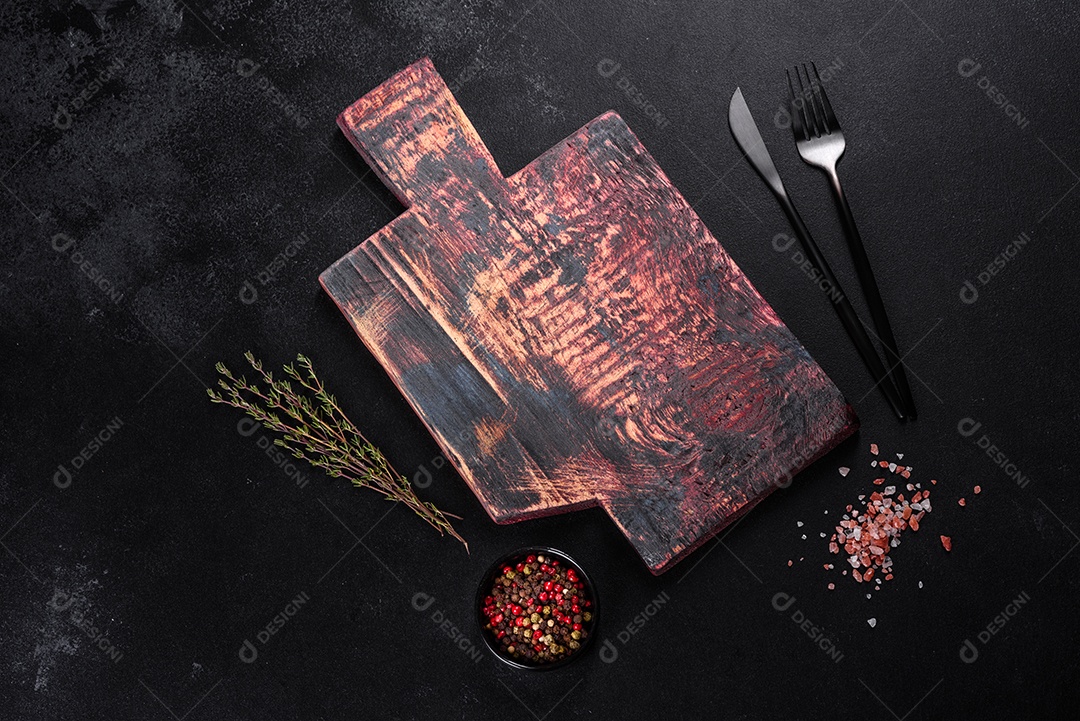 Tábua de corte de madeira, bem como legumes e uma mesa escura especial. Preparação para produção de alimentos