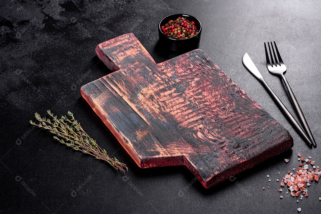 Tábua de corte de madeira, bem como legumes e uma mesa escura especial. Preparação para produção de alimentos