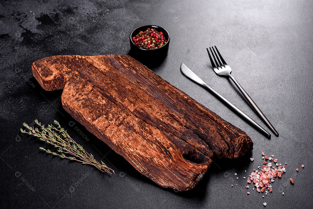 Tábua de corte de madeira, bem como legumes e uma mesa escura especial. Preparação para produção de alimentos