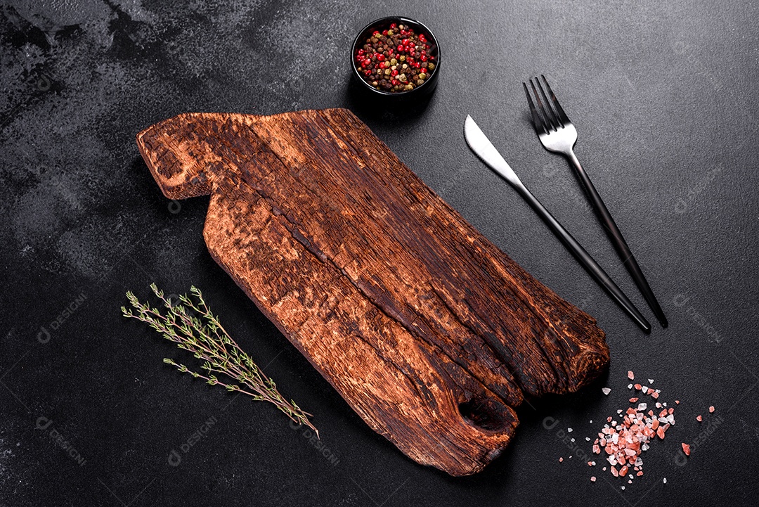 Tábua de corte de madeira, bem como legumes e uma mesa escura especial. Preparação para produção de alimentos