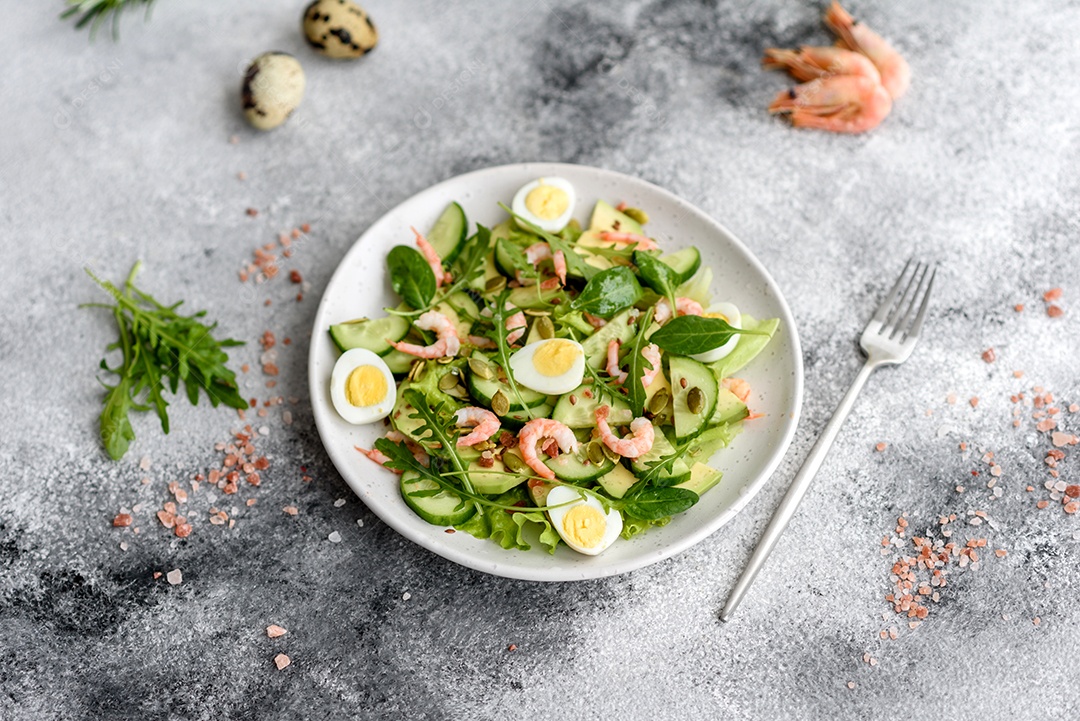 Salada com camarão, abacate, pepino, sementes de abóbora e linhaça com azeite. Prato de comida saudável