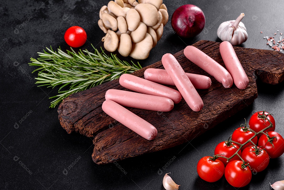 Salsichas cozidas em uma tábua de madeira sobre um fundo escuro de concreto. Alimentos não saudáveis