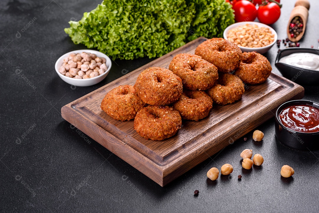 Lindo delicioso falafel de grão de bico fresco com molhos em um fundo de concreto. Elementos da culinária vegetariana