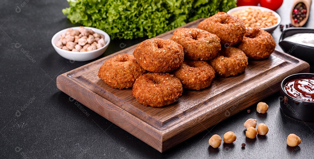 Lindo delicioso falafel de grão de bico fresco com molhos em um fundo de concreto. Elementos da culinária vegetariana