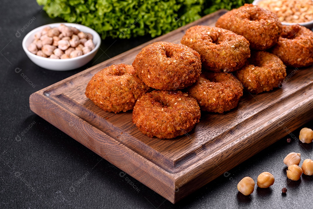 Lindo delicioso falafel de grão de bico fresco com molhos em um fundo de concreto. Elementos da culinária vegetariana