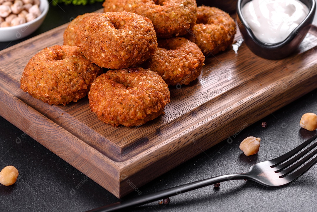 Lindo delicioso falafel de grão de bico fresco com molhos em um fundo de concreto. Elementos da culinária vegetariana