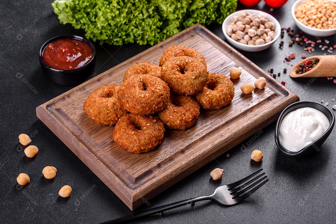 Lindo delicioso falafel de grão de bico fresco com molhos em um fundo de concreto. Elementos da culinária vegetariana