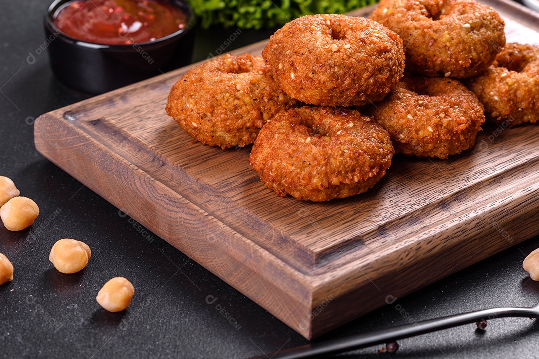 Lindo delicioso falafel de grão de bico fresco com molhos em um fundo de concreto. Elementos da culinária vegetariana