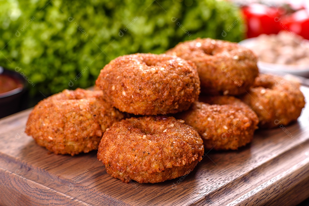 Lindo delicioso falafel de grão de bico fresco com molhos em um fundo de concreto. Elementos da culinária vegetariana