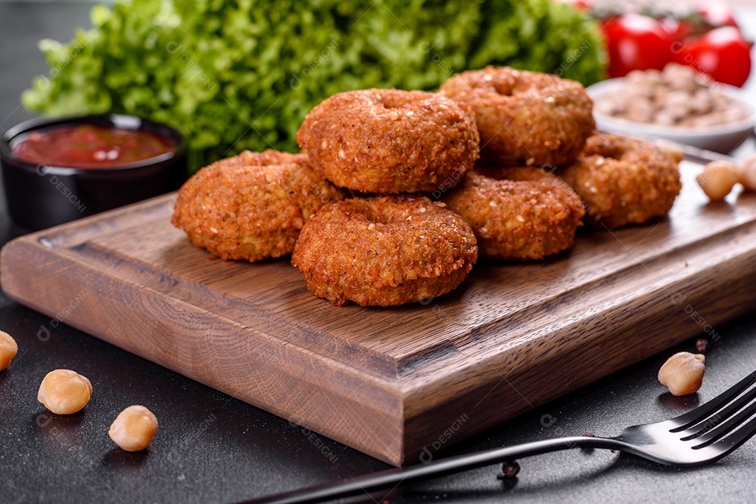 Lindo delicioso falafel de grão de bico fresco com molhos em um fundo de concreto. Elementos da culinária vegetariana
