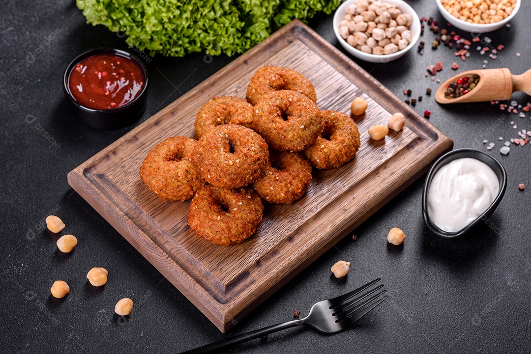 Lindo delicioso falafel de grão de bico fresco com molhos em um fundo de concreto. Elementos da culinária vegetariana