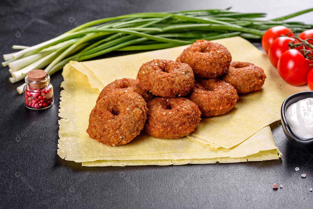 Lindo delicioso falafel de grão de bico fresco com molhos em um fundo de concreto. Elementos da culinária vegetariana