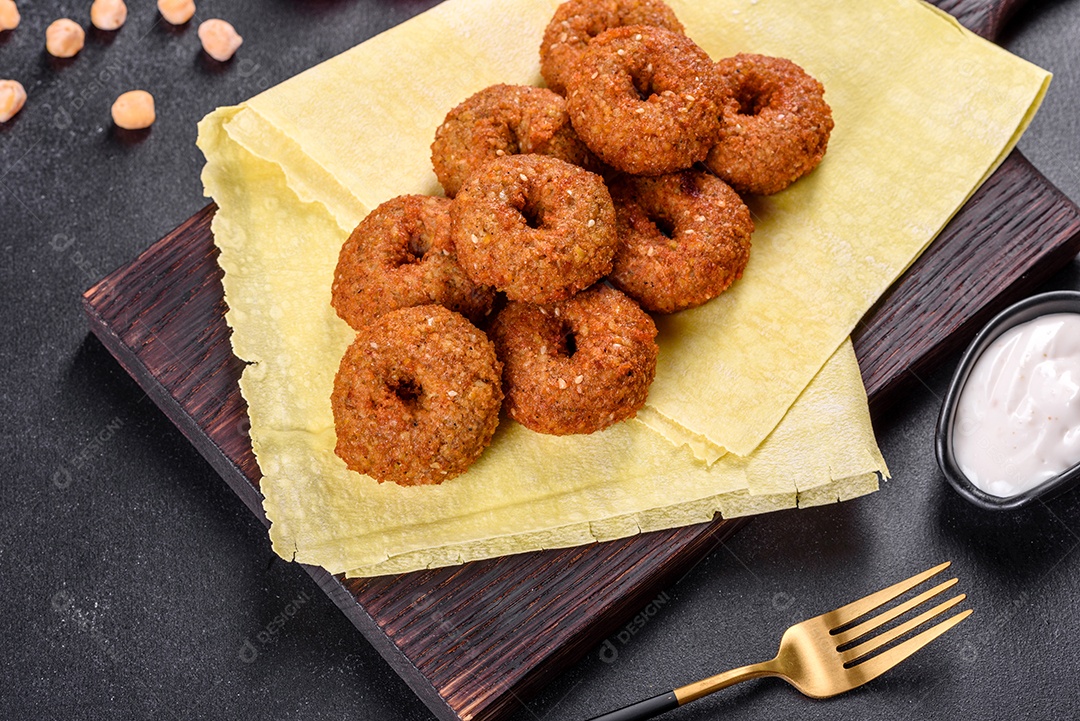 Lindo delicioso falafel de grão de bico fresco com molhos em um fundo de concreto. Elementos da culinária vegetariana