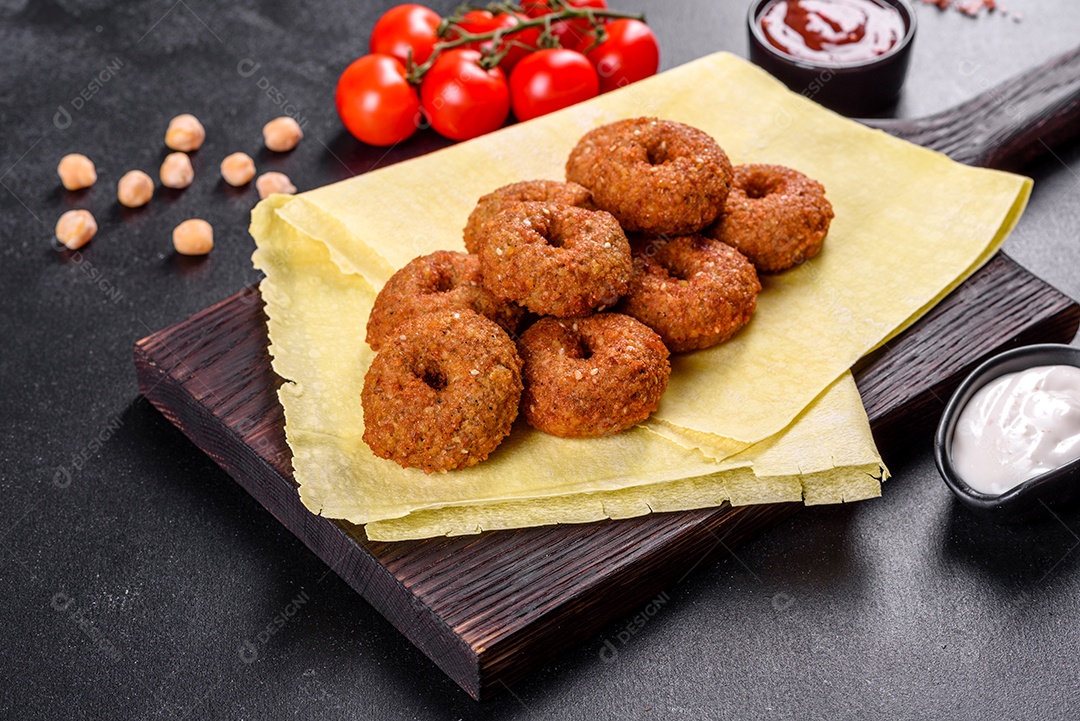 Lindo delicioso falafel de grão de bico fresco com molhos em um fundo de concreto. Elementos da culinária vegetariana