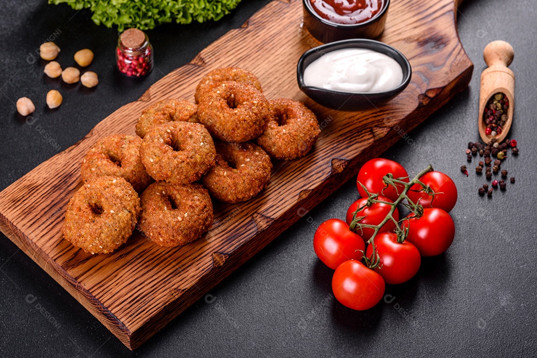 Lindo delicioso falafel de grão de bico fresco com molhos em um fundo de concreto. Elementos da culinária vegetariana