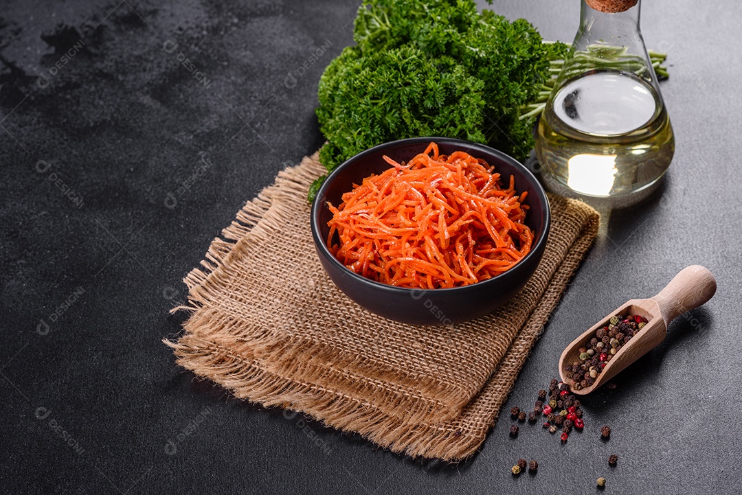 Deliciosas cenouras coreanas suculentas e picantes em pratos cerâmicos sobre um fundo escuro de concreto. Cozinha asiática