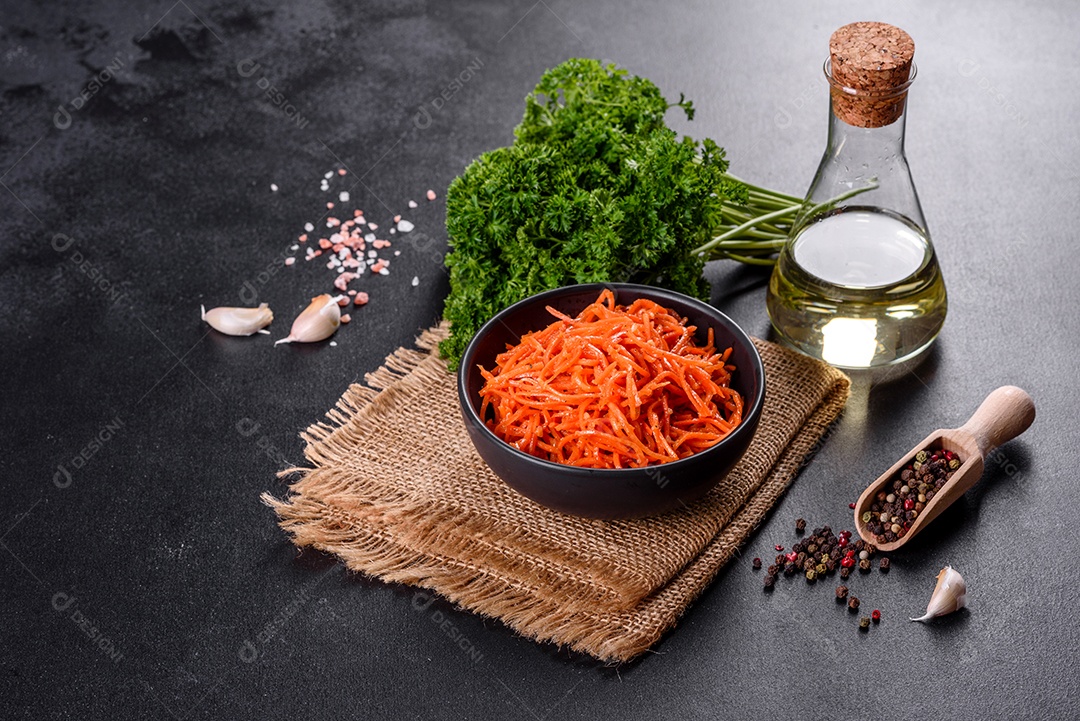 Deliciosas cenouras coreanas suculentas e picantes em pratos cerâmicos sobre um fundo escuro de concreto. Cozinha asiática