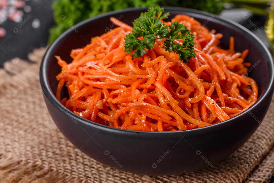 Deliciosas cenouras coreanas suculentas e picantes em pratos cerâmicos sobre um fundo escuro de concreto. Cozinha asiática