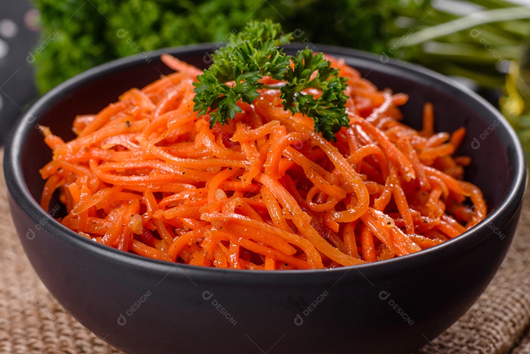 Deliciosas cenouras coreanas suculentas e picantes em pratos cerâmicos sobre um fundo escuro de concreto. Cozinha asiática