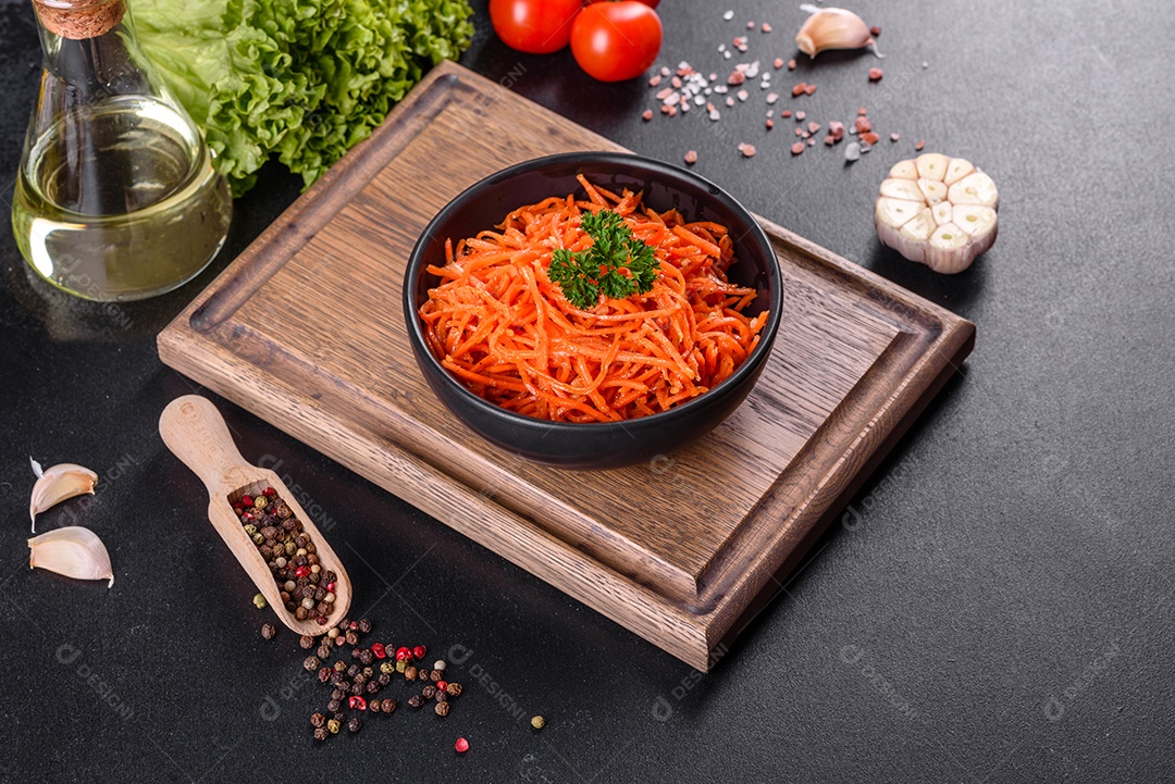Deliciosas cenouras coreanas suculentas e picantes em pratos cerâmicos sobre um fundo escuro de concreto. Cozinha asiática