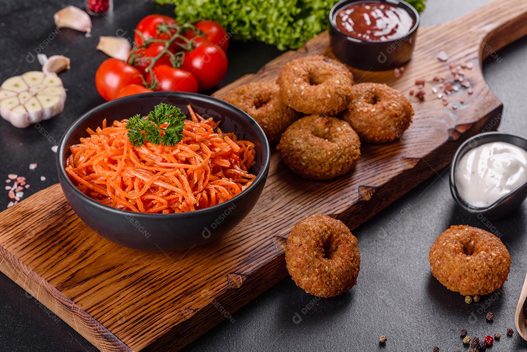 Deliciosas cenouras coreanas suculentas e picantes em pratos cerâmicos sobre um fundo escuro de concreto. Cozinha asiática