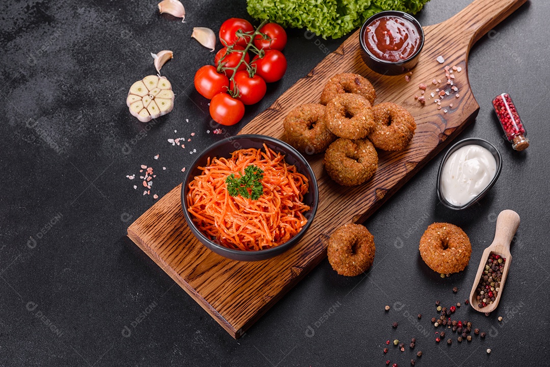 Deliciosas cenouras coreanas suculentas e picantes em pratos cerâmicos sobre um fundo escuro de concreto. Cozinha asiática