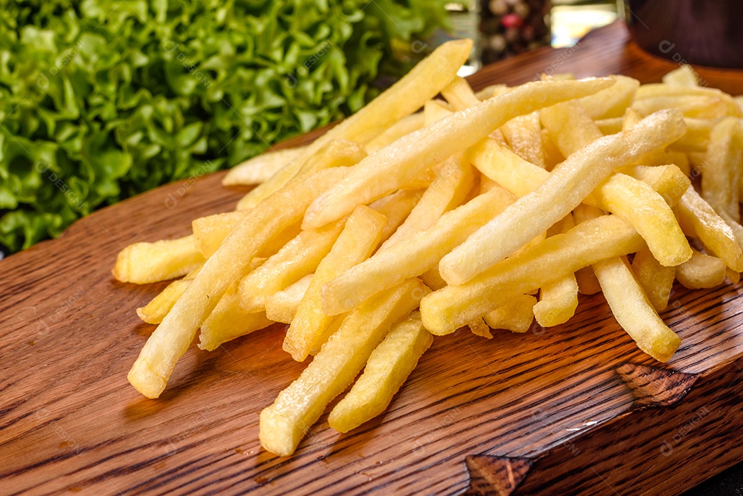 Batatas fritas sobre tábua de madeira