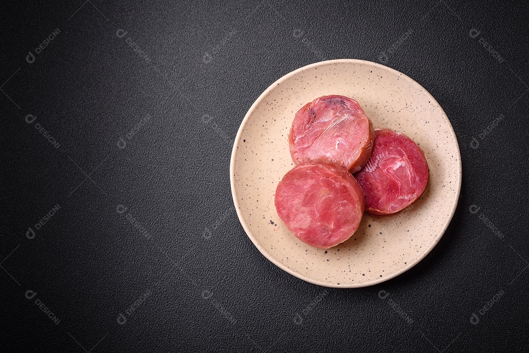 Bifes redondos de atum suculento cru com sal e especiarias sobre um fundo escuro de concreto