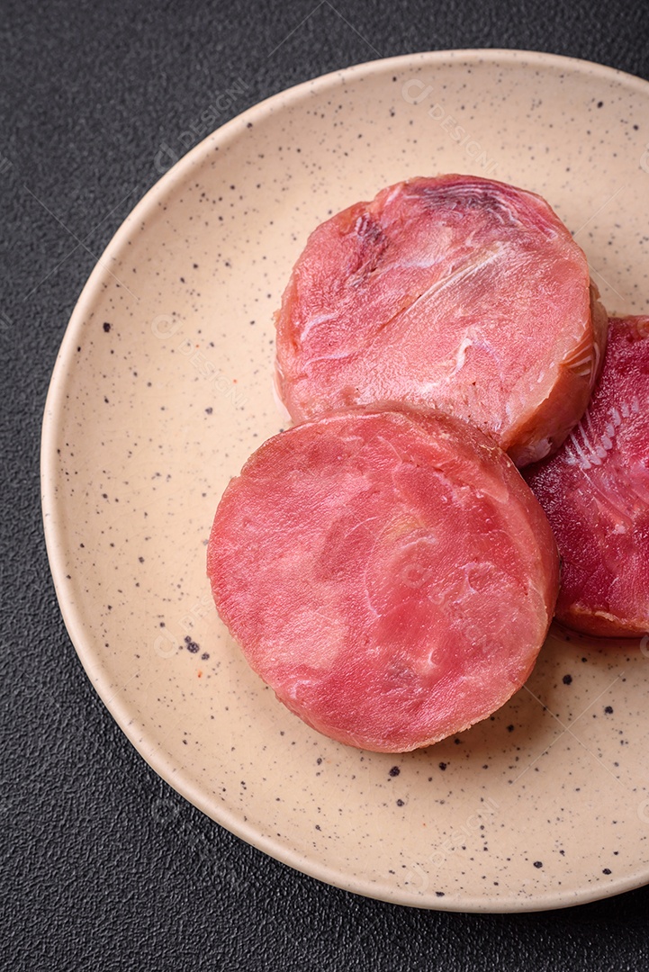 Bifes redondos de atum suculento cru com sal e especiarias sobre um fundo escuro de concreto