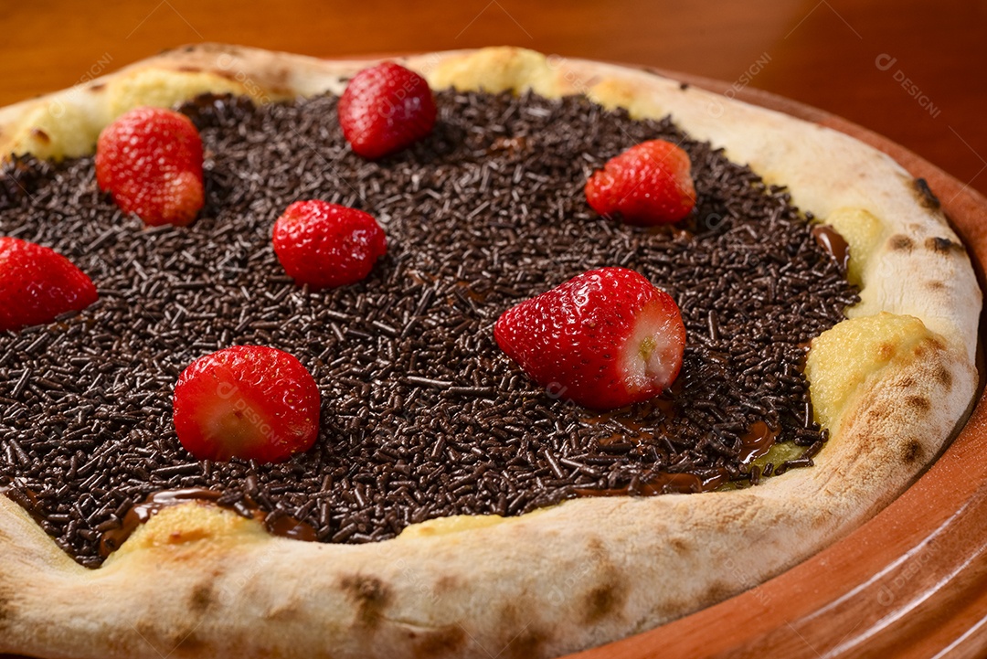 Pizza de morango com chocolate na mesa de madeira