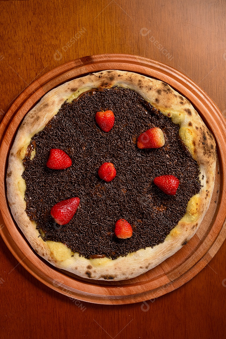 Pizza de morango com chocolate na mesa de madeira