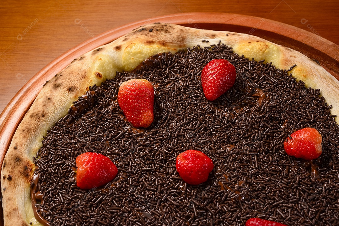 Pizza de morango com chocolate na mesa de madeira