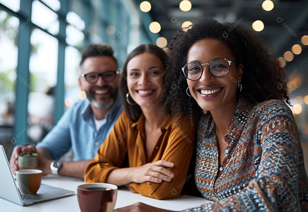 Três colegas de trabalho sorridentes e diversos tendo uma reunião informal de estratégia empresarial