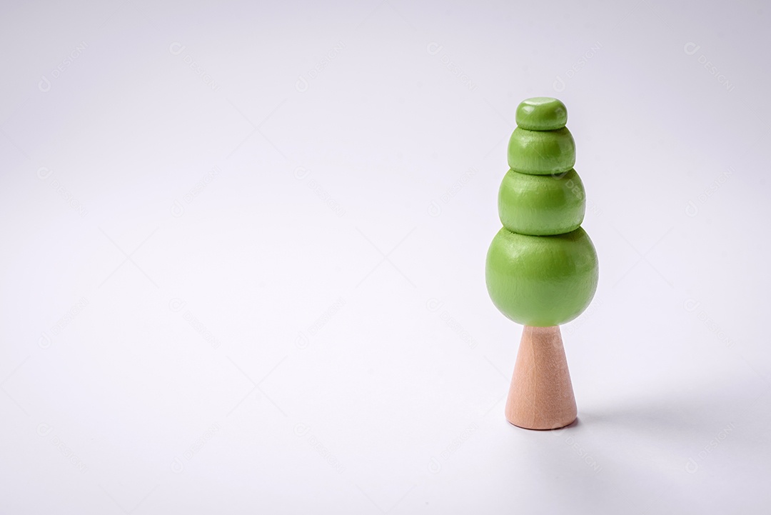 Modelo de madeira de uma árvore com copa verde e tronco sobre fundo branco. Crescimento infantil com brinquedos de madeira