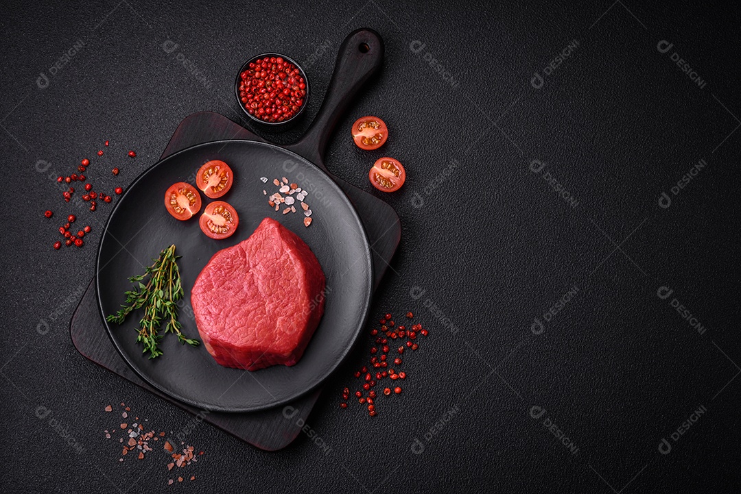 Carne crua fresca e suculenta com sal, especiarias e ervas sobre um fundo de concreto texturizado escuro