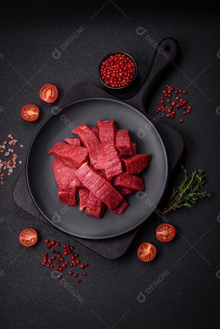 Carne crua fresca e suculenta com sal, especiarias e ervas sobre um fundo de concreto texturizado escuroCarne crua comida alimento sobre mesa fundo isolado Fotos Imagens JPG