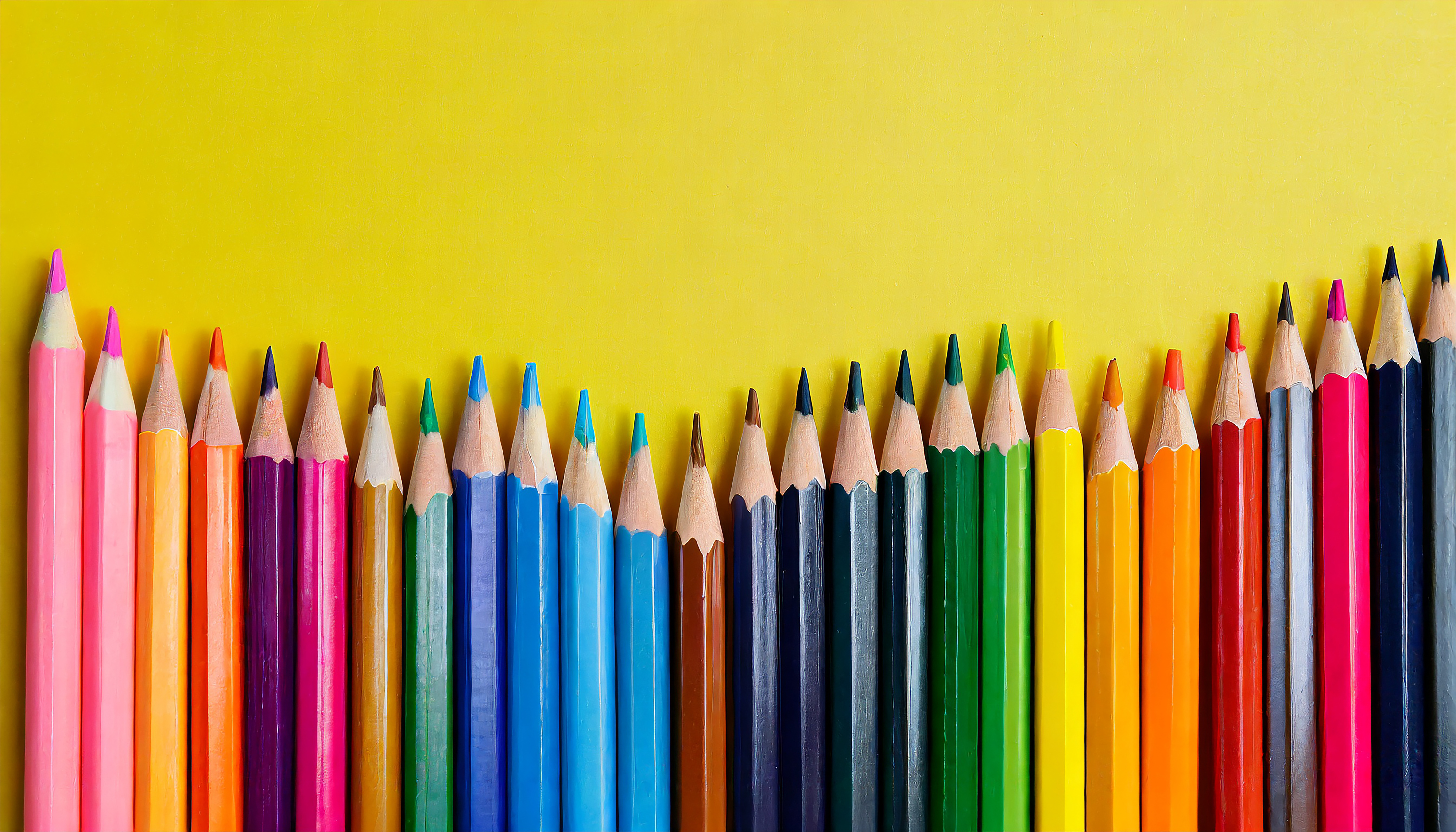 Uma fileira de lápis de cor sobre um fundo amarelo