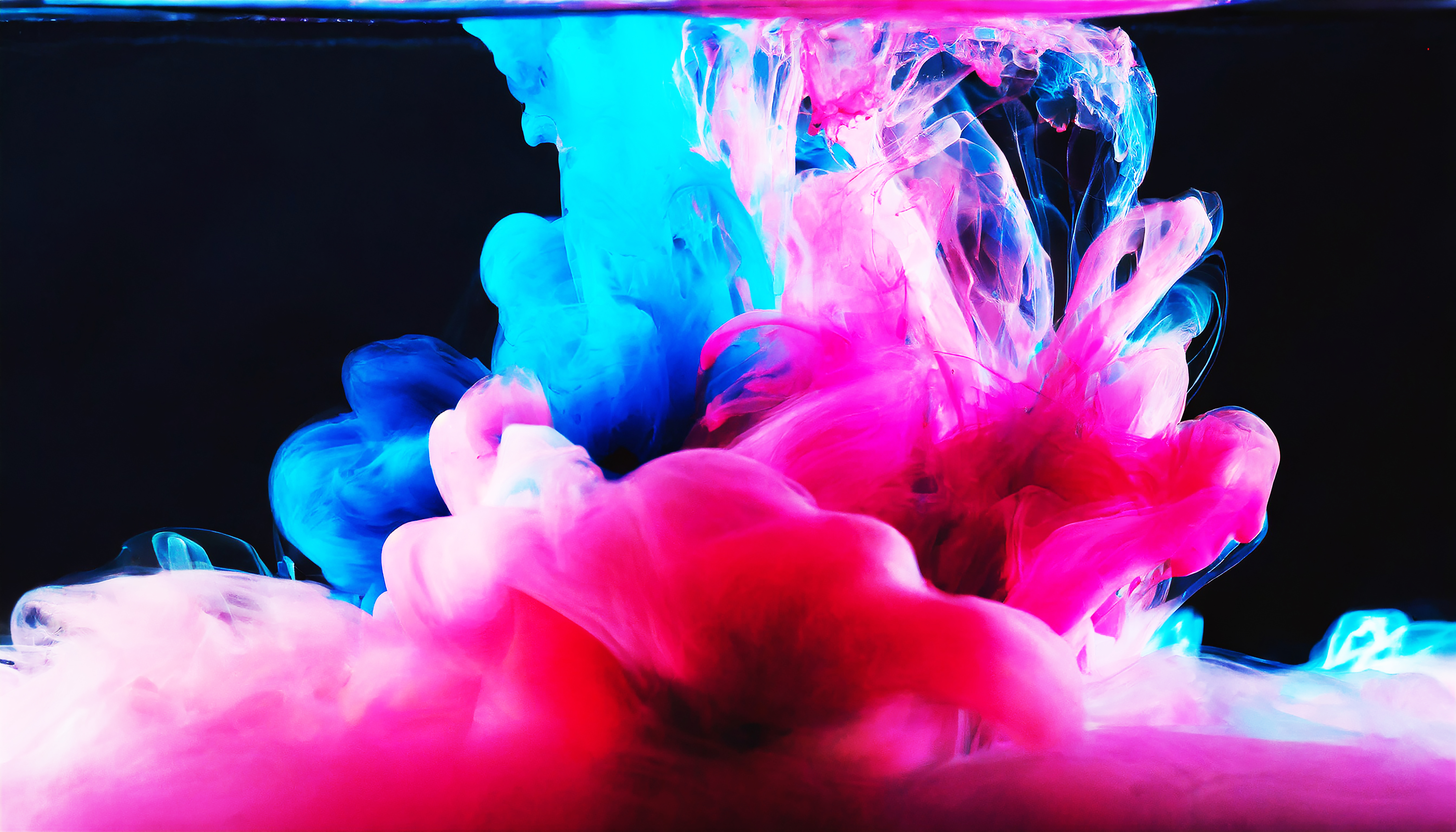 Corante abstrato colorido rosa e azul em água em fundo escuro
