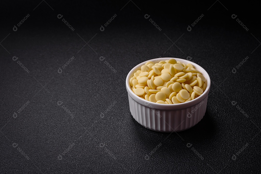 Grânulos redondos de chocolate doce de confeitaria como ingrediente ou preparação para a preparação de deliciosas sobremesas. Fazendo doces em casa