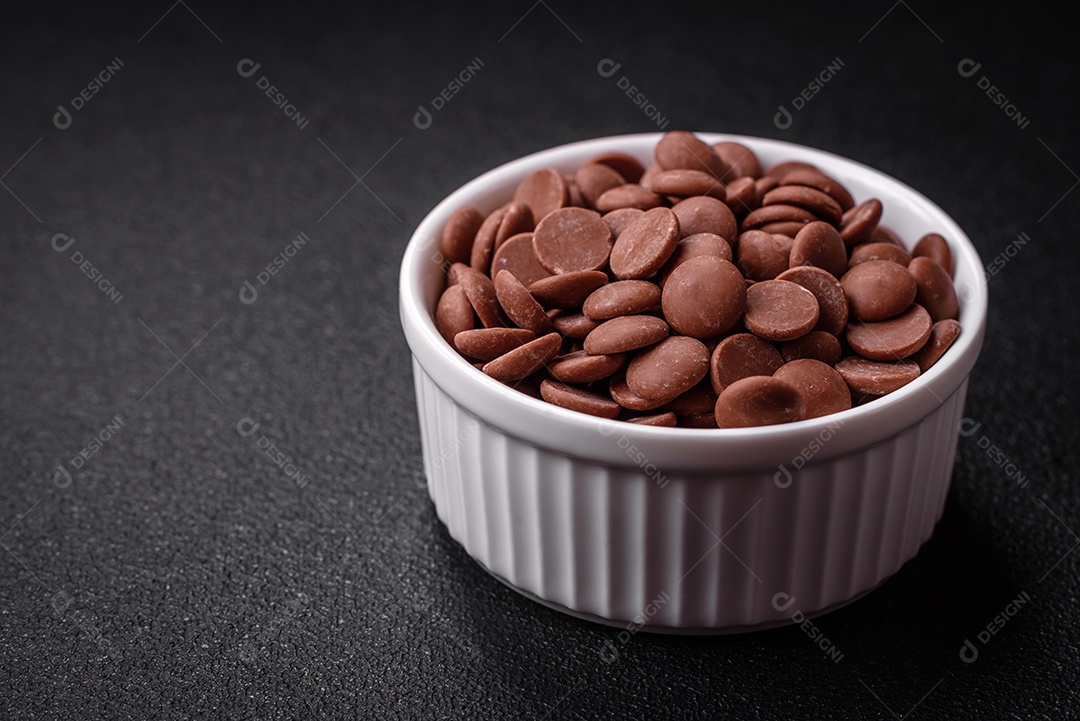 Grânulos redondos de chocolate doce de confeitaria como ingrediente ou preparação para a preparação de deliciosas sobremesas. Fazendo doces em casa