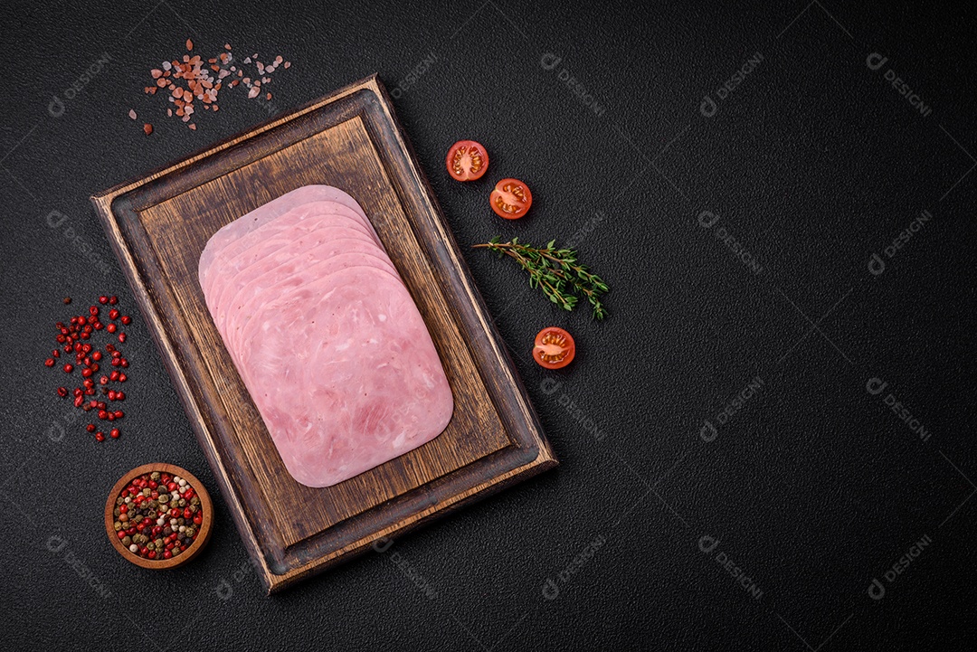 Delicioso presunto fresco cortado em fatias com sal, especiarias e ervas sobre um fundo escuro de concreto