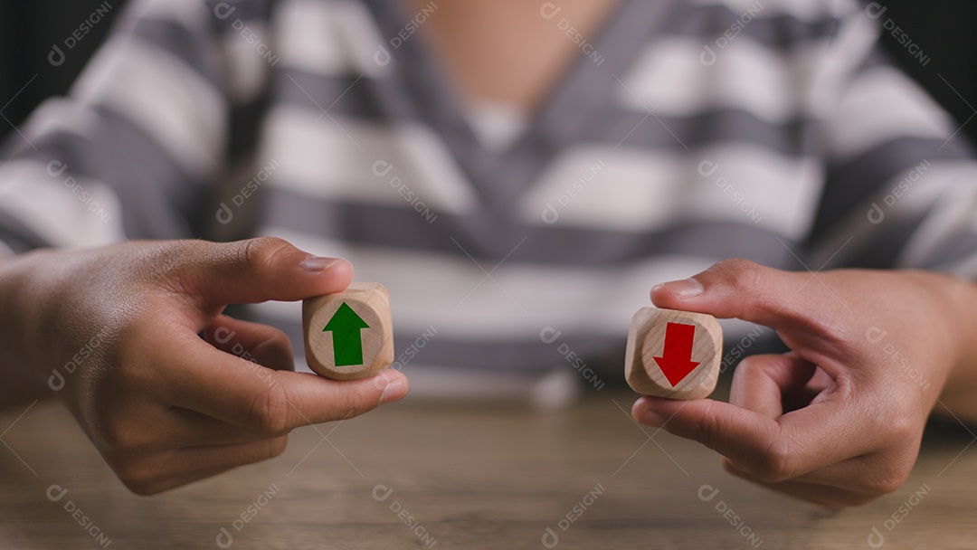 Mãos de pessoa segurando cubos de madeira