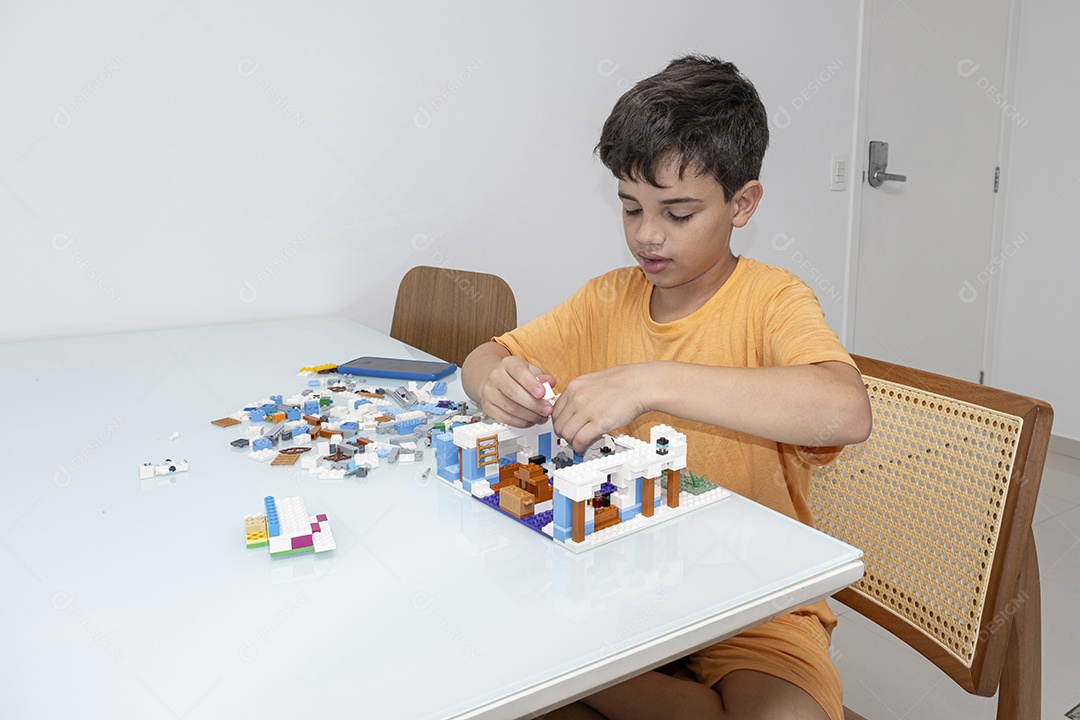 Criança brasileira de 10 anos de pijama brincando com blocos de construção.