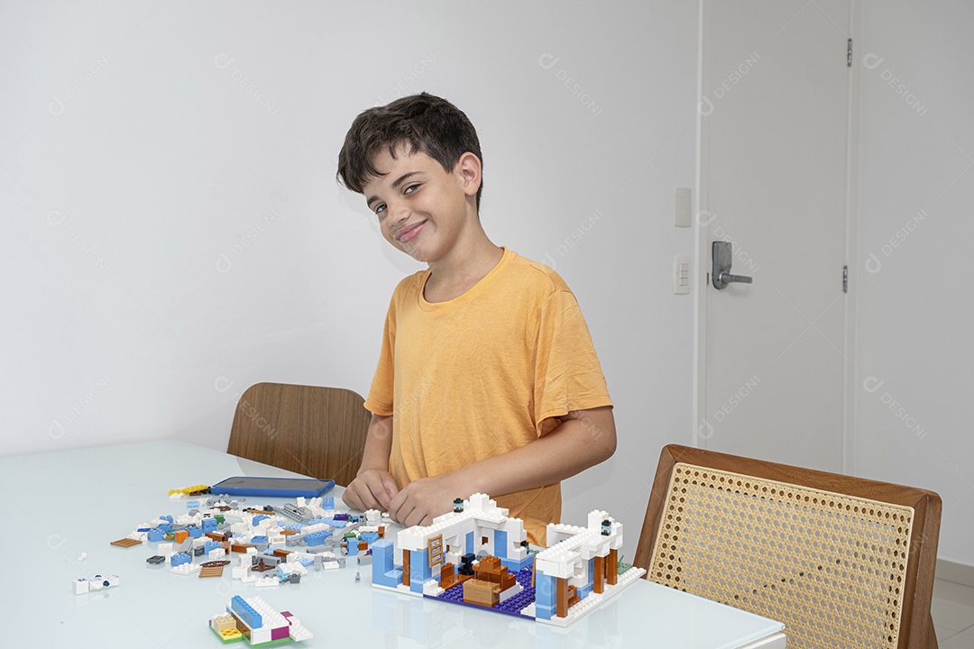 Criança brasileira de 10 anos de pijama brincando com blocos de construção.