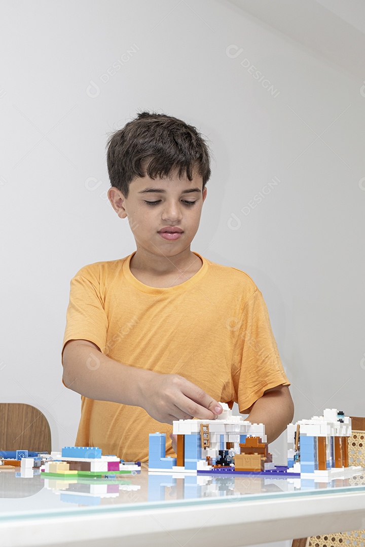 Criança brasileira de 10 anos de pijama brincando com blocos de construção.