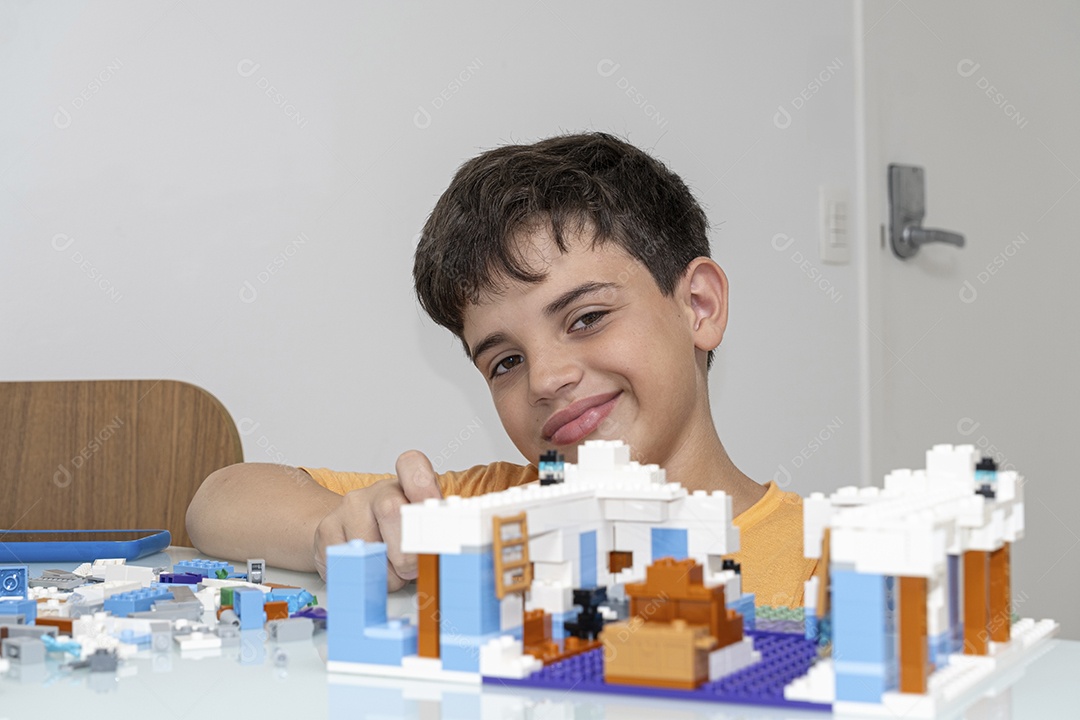 Criança brasileira de 10 anos de pijama brincando com blocos de construção.