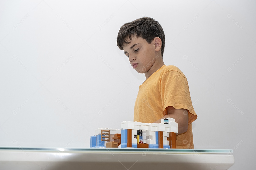 Criança brasileira de 10 anos de pijama brincando com blocos de construção.