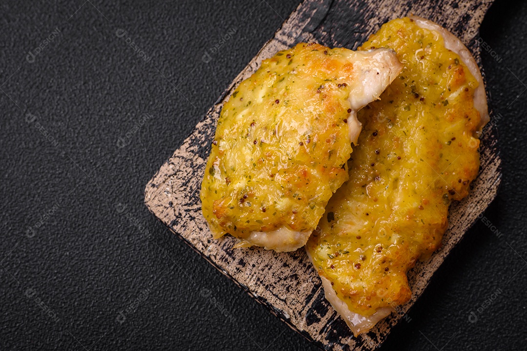 Deliciosa carne frita com mostarda Dijon com sal, especiarias e ervas sobre fundo escuro de concreto
